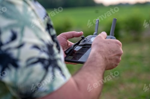 Preview: A man holding a remote control of a drone in his hand, close-up