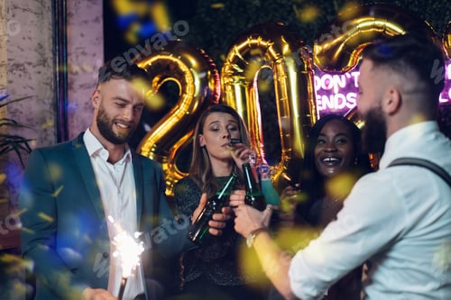 Visualização: Feliz grupo de amigos celebra a véspera de Ano Novo em um clube