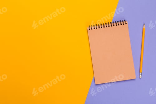 Preview: Creative workspace with a notebook and pencil on colored background