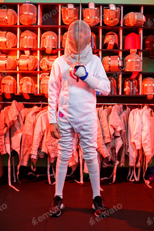 Preview: Young guy in a fencing suit with a sword in his hand, on a red background, neon light.