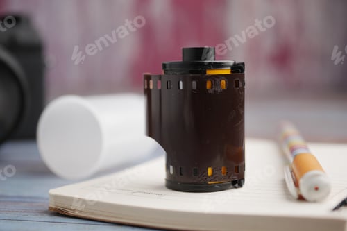 Preview: Film roll on a notebook with a camera in the background
