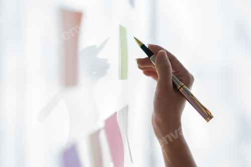 Preview: Cropped image of businessman hand holding pen pointing at various colorful notepads mounted on glass