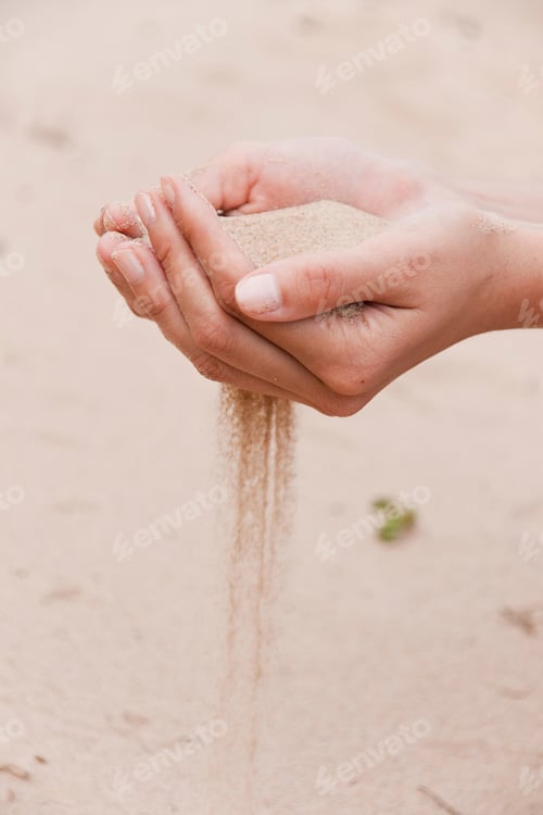 Preview: Sand flows through female fingers