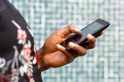 Preview: Closeup of african woman hand holding touchscreen mobile phone