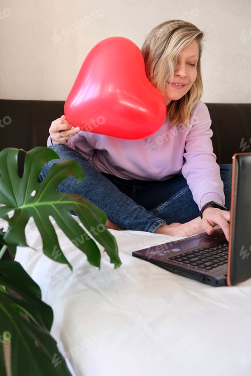 Preview: Woman Relaxing with Laptop and Red Heart Balloon