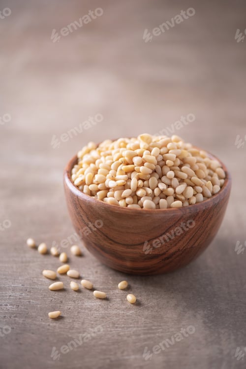 Preview: Shelled raw pine nuts in wooden bowl on wood textured background. Copy space. Superfood, vegan