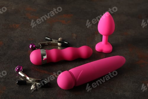 Preview: Sex toys of pink color on a dark background