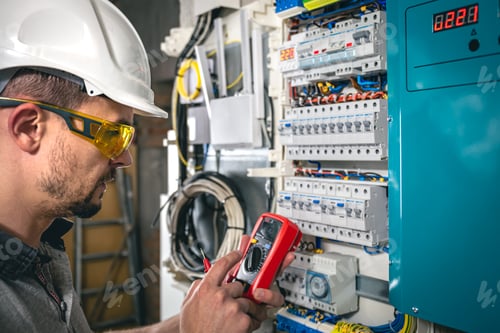 Preview: Man, an electrical technician working in a switchboard with fuses.
