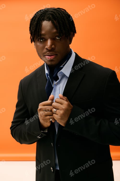 Preview: Handsome young man showcasing stylish attire against a vibrant background in a modern setting