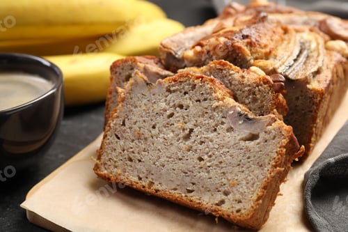 Preview: Cut banana bread with nuts and coffee on black table, closeup