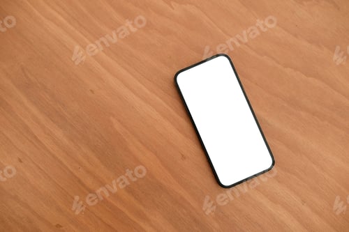 Preview: Cropped shot top view of smartphone mockup at the wooden desk. Blank screen mobile phone for