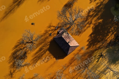Preview: Aerial view of sinking village house in the middle of toxic mine decanting lake