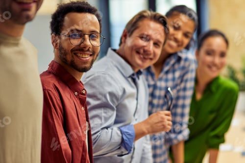 Preview: Successful team. Group of young happy multi ethnic business team looking at camera and smiling while