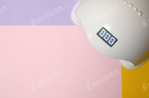 Preview: UV LED nail lamp for curing process by gel method lies on pastel