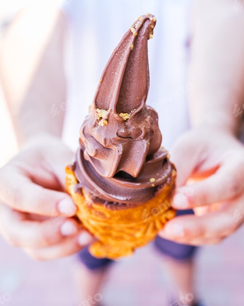 Preview: Man holding a Taiyaki fish with chocolate ice cream close-up
