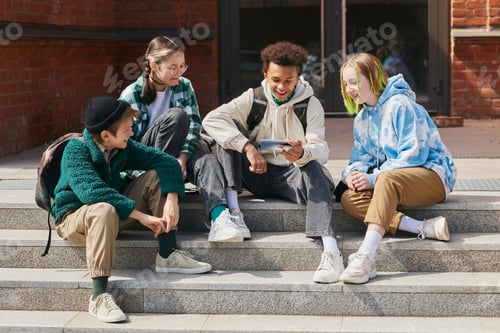 Preview: Teenage students watching funny video on smartphone