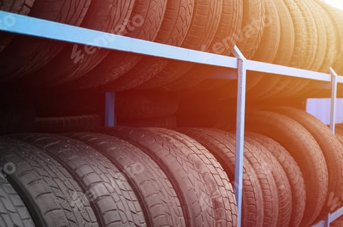 Preview: Rack with variety of car tires in automobile store. Many black tires. Tire stack background