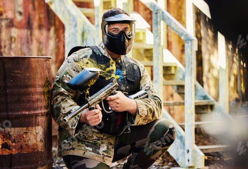 Preview: Paintball, portrait or male soldier with gun in shooting game playing with on war battlefield missi