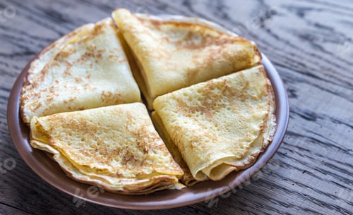 Golden Crepes Stacked on a Plate on Table