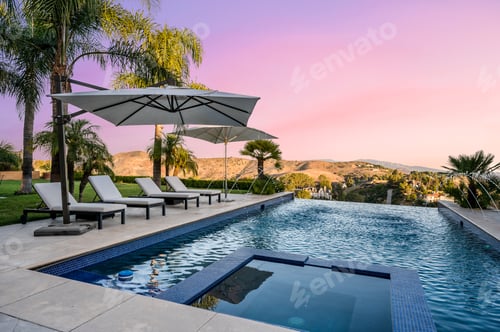 Preview: a beautiful pool at sunset with loungers and umbrellas