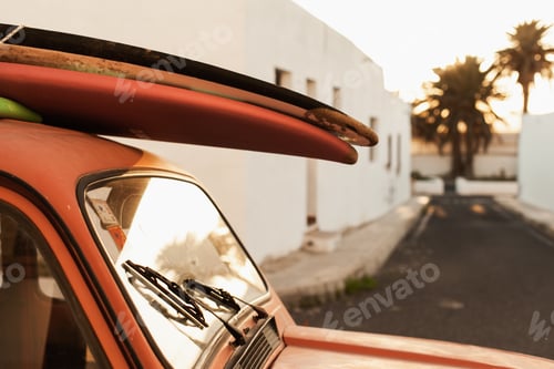 Preview: stack of surfboards on a retro car roof with sun shining. Summer and surf background wallpaper.
