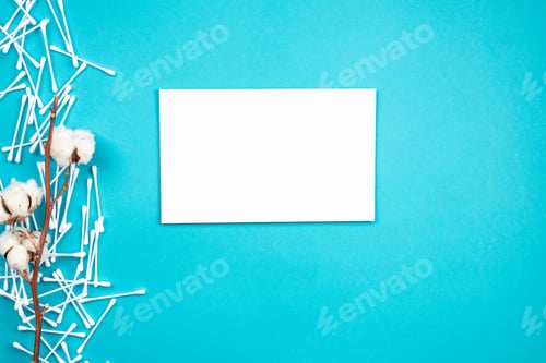 Preview: Blank sheet, cotton and ear sticks on blue background. place for advertising, copy space.