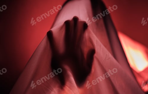 Preview: Hand, fabric and red with a person under a sheet in a bedroom or studio on a red background for psy