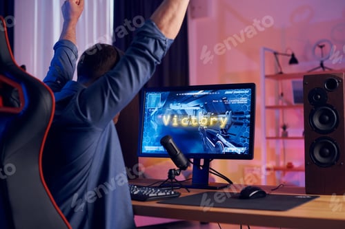 Preview: Celebrating the victory. Online streamer playing FPS shooter game at home