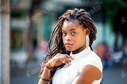 Preview: Portrait of a happy afro American woman standing on street.