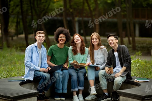 Preview: Group Of Happy Multiracial High-School Students Sitting Together On Bench In Park