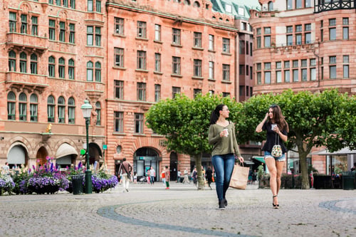 Preview: Two young women walking through town square