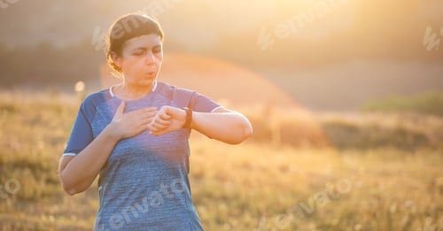Preview: Female checking heartrate and pulse from smart watch monitor, running healthy lifestyle concept.