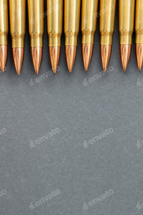 Preview: Bullets on gray paper background. Cartridges 7.62 caliber for Kalashnikov assault rifle