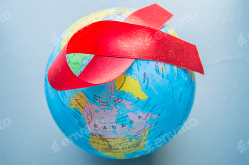 Preview: World AIDS day 1 December, close-up of world globe with red ribbon