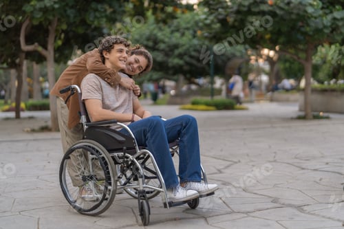 Preview: Young woman embracing a handicapped friend in wheelchair
