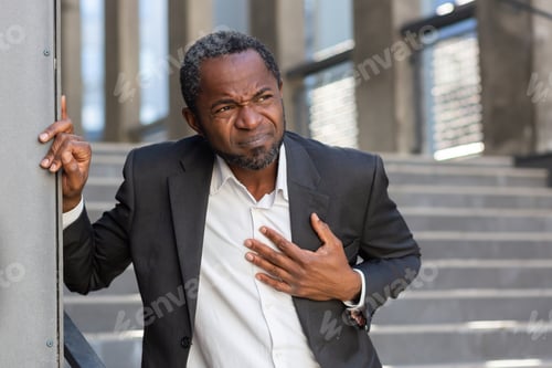 Preview: Heart attack , african american businessman has severe chest pain , man holding his hands over