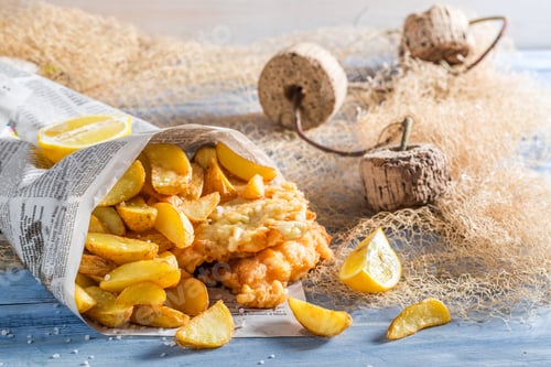 Preview: Hot fish and chips with lemon on old wooden table