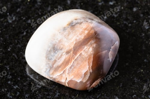 Preview: sample of tumbled nepheline mineral on black