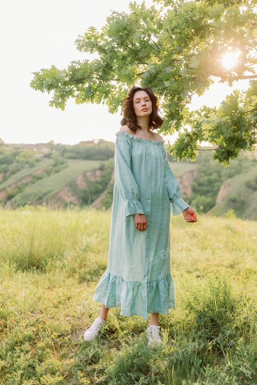 Preview: Pretty girl in a beautiful dress walks in a field and smiles sincerely