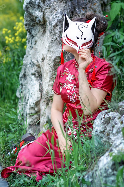 Preview: A Asian girl walks in national clothes with a white mask in the park. Chinese woman