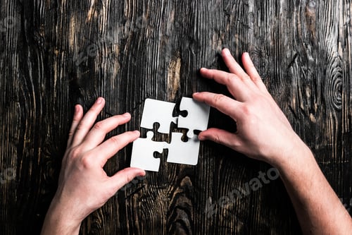 Preview: hands with pieces of jigsaw