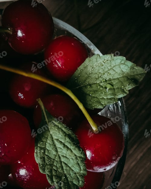 Fresh Ripe Cherries with Mint Leaves in Glass