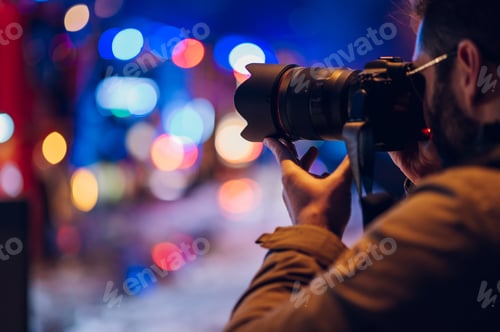 Preview: Reporter photographer shooting in the city street in the night