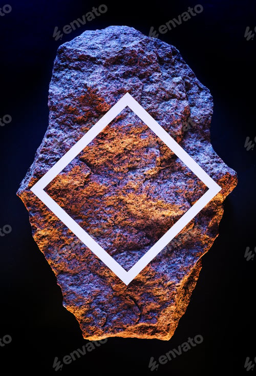 Preview: Meteorite stone in dark space with white frame of copy space neon fluorescent lighting.