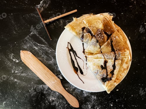Preview: Crepes with Chocolate and Powdered Sugar on Plate