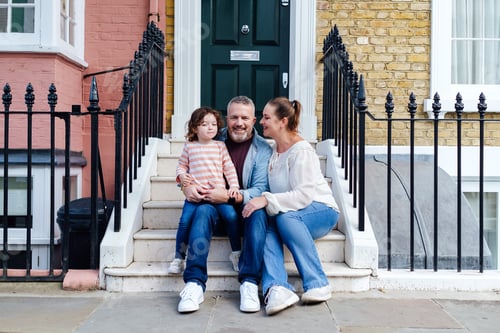 Preview: Family sitting together on front step of their house