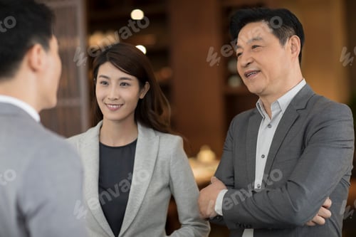 Preview: Cheerful Chinese business people talking indoors