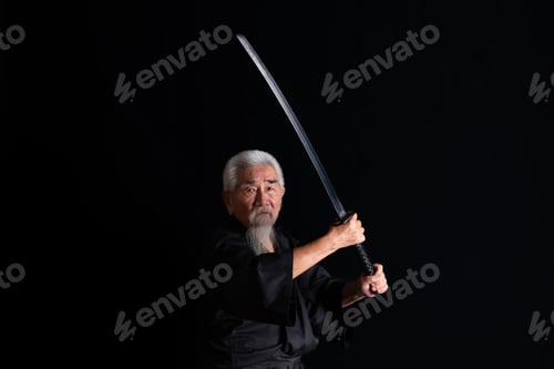 Preview: Senior Japanese samurai with katana sword on black background, studio shot