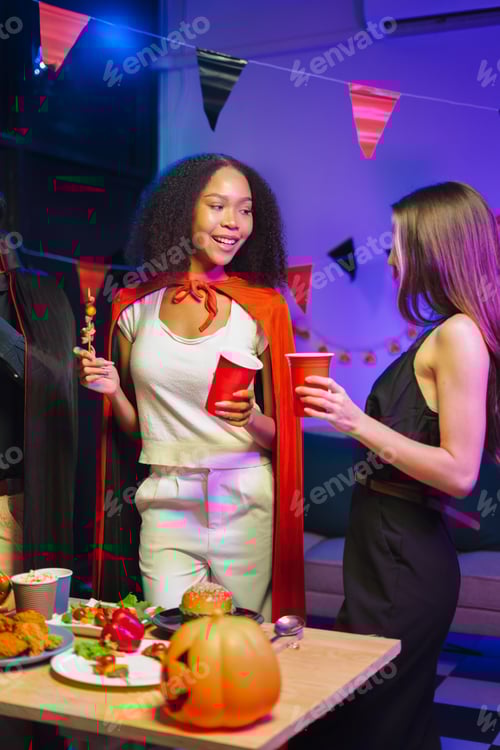 Visualização: Amigos comemoram o Halloween com um jantar, alegres.