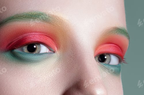 Preview: Eyes of young beautiful woman with clear glowing skin and pink green makeup closeup